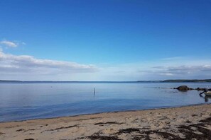 A beach with calm water, a sandy shore, and distant landforms. - Holiday apartment with 1 bedroom (Glücksburg)