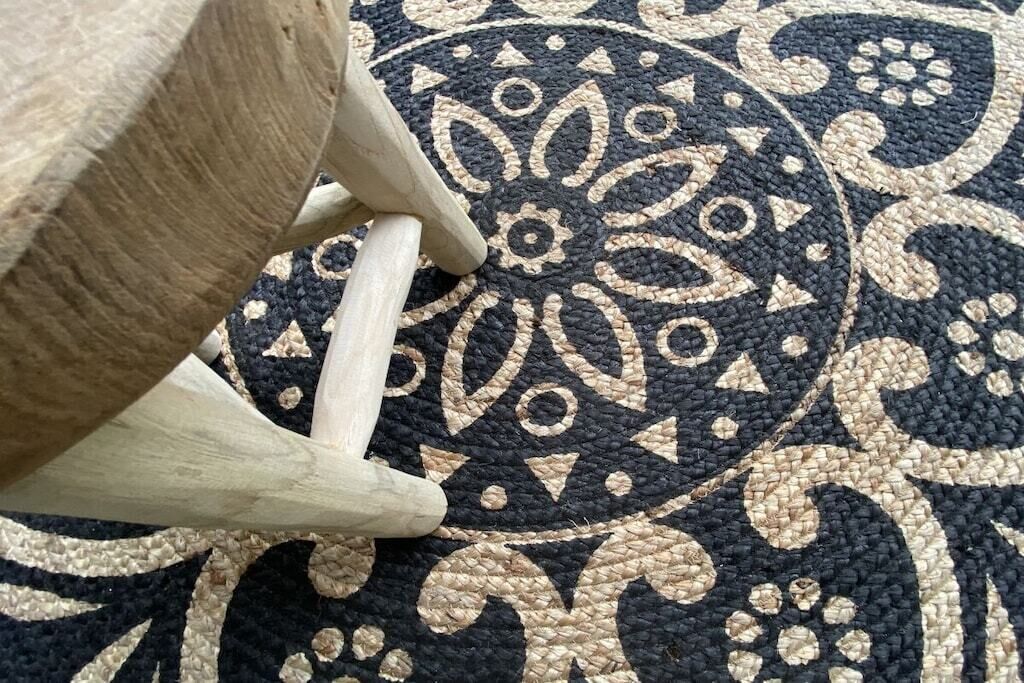 Un gros plan d’un tapis tissé orné d’un motif circulaire.