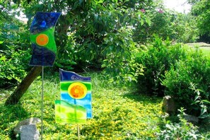 Two flags with a circular design, set against a backdrop of lush greenery and a tree. - Holiday apartment with 3 bedrooms (Bodenmais)