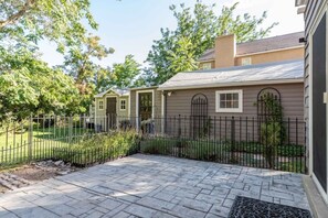 A residential property with a paved patio, a metal fence, and a house with a grey exterior. - Red Butte River Gem-Close to the U, Downtown & Mtn (Salt Lake City)