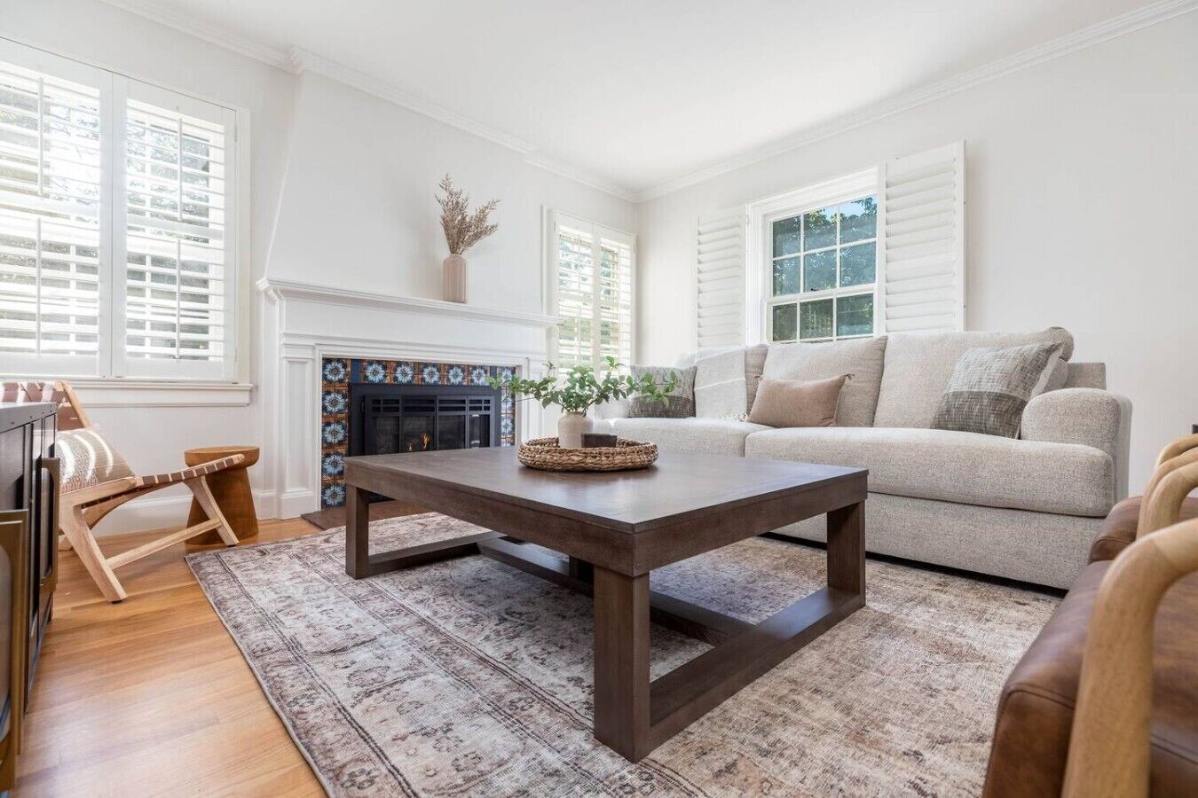 A living room with a fireplace, a sofa, a coffee table, and a wooden chair.