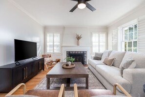 A living room with a flat-screen TV, a fireplace, a sofa, and a coffee table. - Red Butte River Gem-Close to the U, Downtown & Mtn (Salt Lake City)
