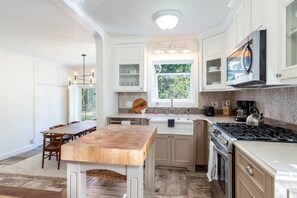 A modern kitchen with white cabinetry, a wooden island, and a gas stove. - Red Butte River Gem-Close to the U, Downtown & Mtn (Salt Lake City)