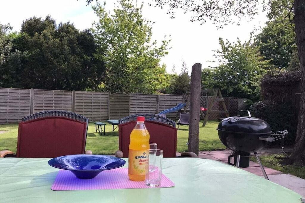Pöydällä on appelsiinimehua sisältävä pullo, lasi ja sininen kulho.