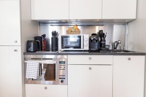 A kitchen with a built-in microwave, oven, and coffee maker. - Central London 1BR | Trafalgar Square | Sleeps 4 (London)