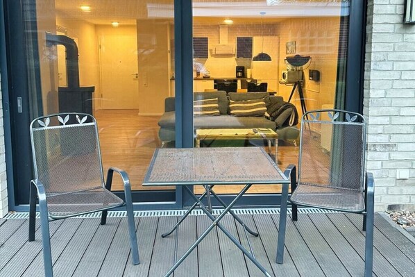 Un salon moderne avec un canapé, une table basse et deux fauteuils à structure en treillis.