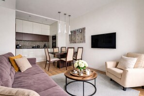 A modern living room with a sofa, a coffee table, and a dining area with chairs and a table. - Old Town Gdansk with Parking - Tandeta 1 (Gdańsk)