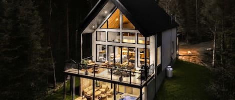Una casa moderna con balcón, ventanas amplias y un interior bien iluminado.