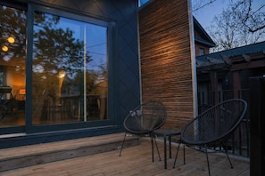 A modern outdoor seating area with two chairs and a wooden deck.