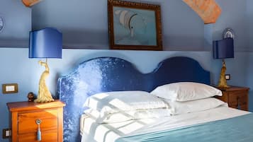 Une chambre à coucher avec un lit, deux tables de chevet, une commode, un tableau et un plafond en arc de cercle.
