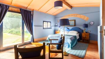 Une chambre à coucher avec un lit, une chaise, un bureau et une fenêtre.