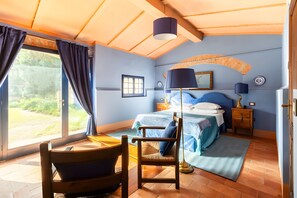 Ein Schlafzimmer mit Bett, Stuhl, Schreibtisch und Fenster.