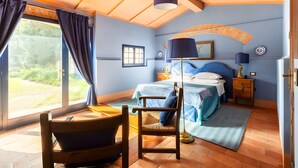 Un dormitorio con una cama, una silla, un escritorio y una ventana.