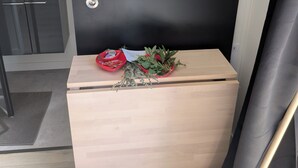A small wooden cabinet with a mirror above it, a sink with a faucet, and a door with a lock.