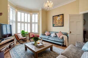 A living room with a sofa, armchairs, a coffee table, and a chandelier. - Luxury 6BR Beach House Hot Tub Sea View (Cromer)