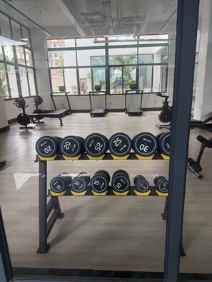 A gym with weightlifting equipment, treadmills, and exercise bikes. - New Luxury Furnish 1BR @Kilimani w/ Pool, Sauna & Gym | Walk to Yaya & Dining (Nairobi)