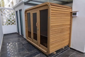 A wooden cabinet with glass doors, positioned against a white wall with a tiled floor. - New Luxury Furnish 1BR @Kilimani w/ Pool, Sauna & Gym | Walk to Yaya & Dining (Nairobi)