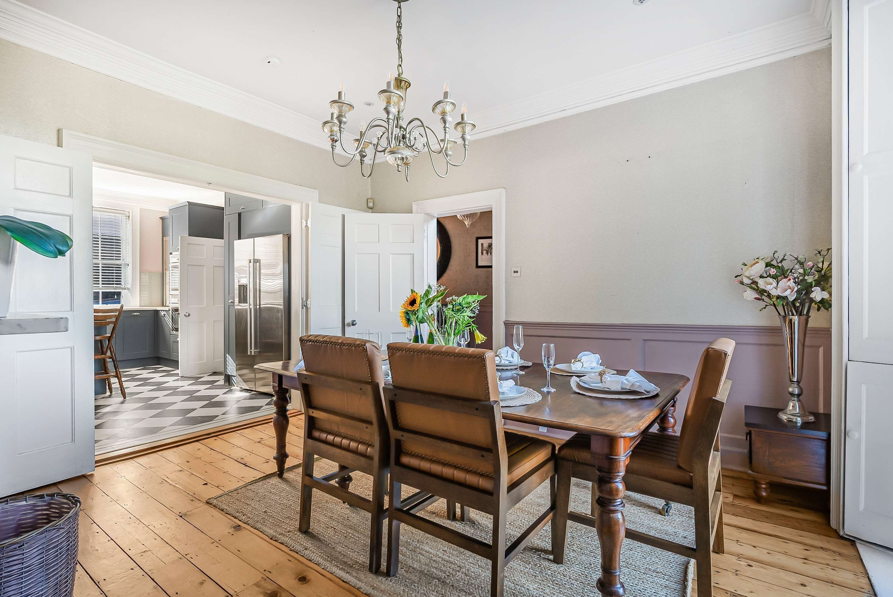 A dining area with a wooden table, six chairs, and a chandelier.
