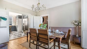 A dining area with a wooden table, six chairs, and a chandelier.