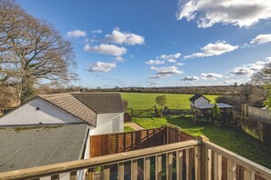 A residential area with a view of a green field, a wooden fence, and a clear sky. - Large 6 Bed Windsor Stay Near Legoland M4 (Maidenhead)