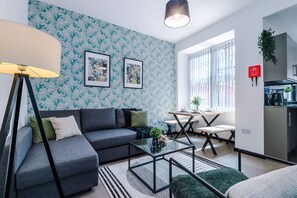 Un salon moderne avec un canapé, une table basse et des œuvres d’art accrochées au mur.