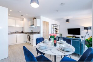 A modern apartment with a dining area, kitchen, and living space. - Modern 2 Bed Duplex Free Parking Wi Fi (Salford)