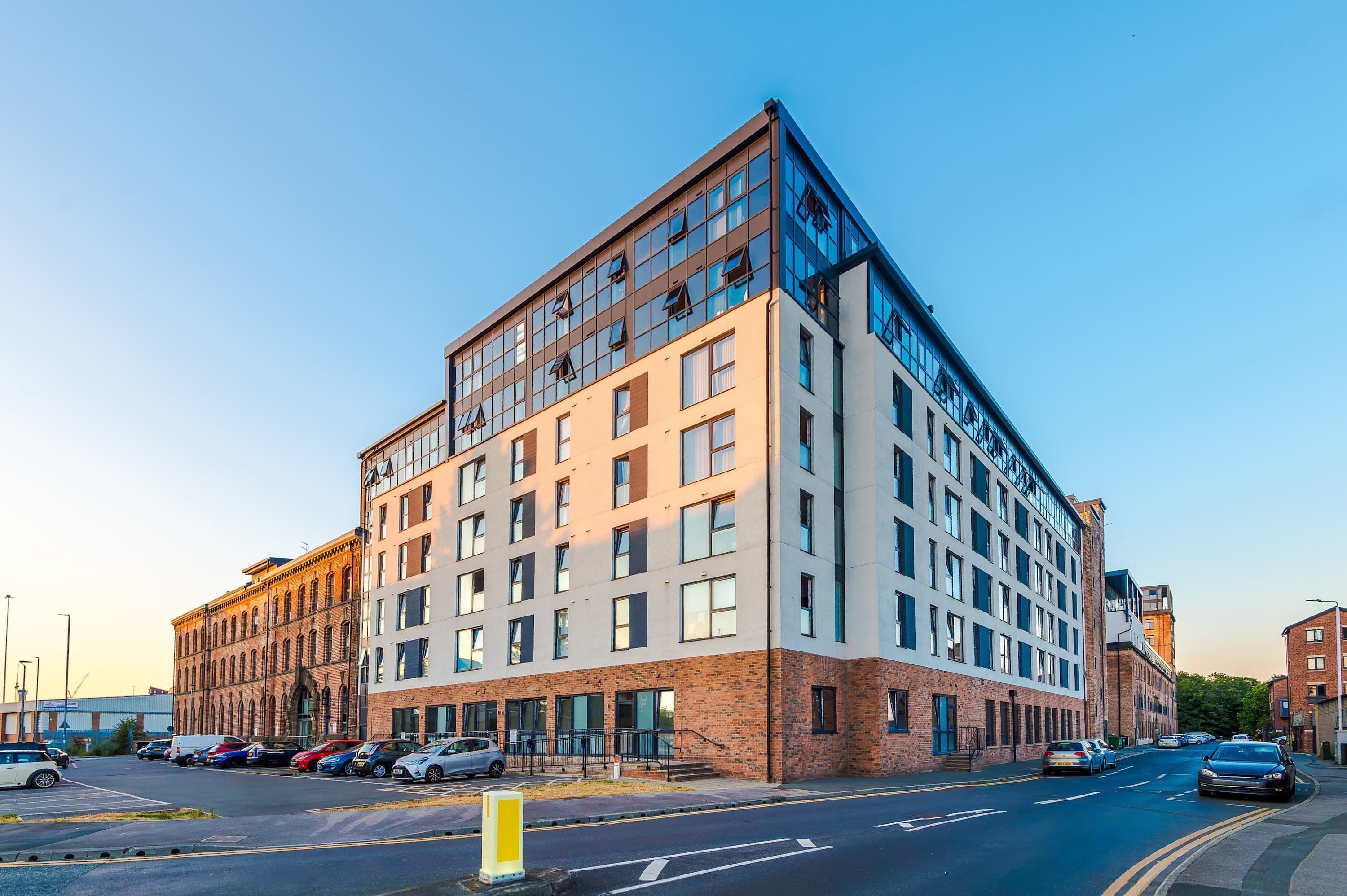 A multi-story building with a modern architectural design, featuring large windows and a flat roof.