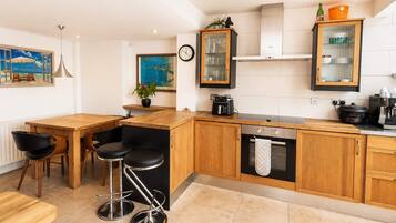 Una cocina moderna con armarios de madera, horno empotrado y cafetera.