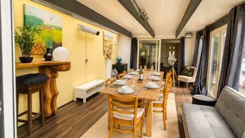 A dining area with a wooden table set for a meal, surrounded by chairs.