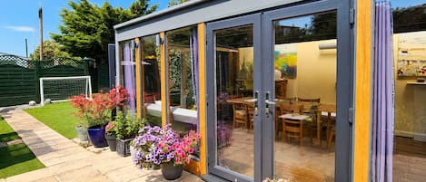 A modern house with a patio, a dining area, and a garden.