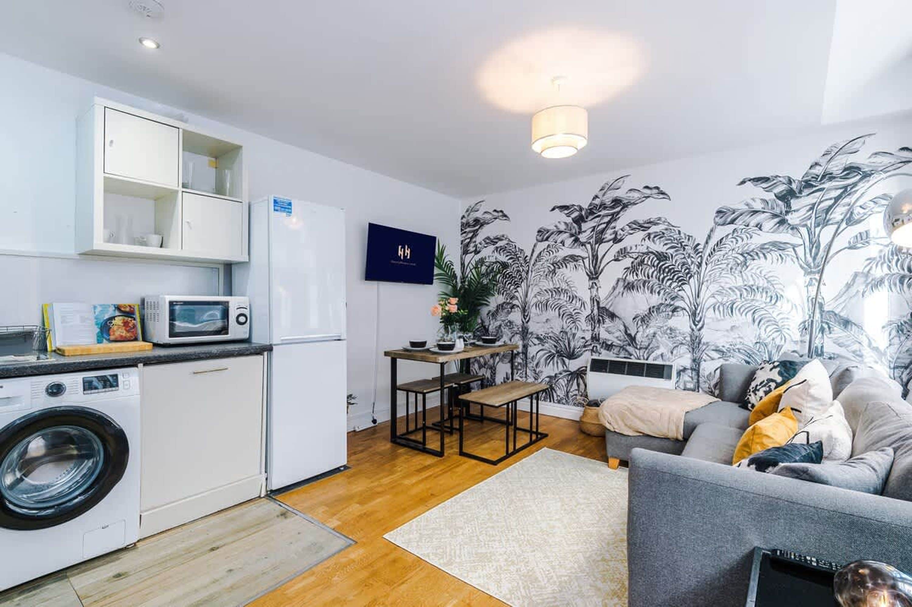 Un espace de vie compact comprenant un coin cuisine, un coin repas et un espace détente avec un canapé et une table basse.