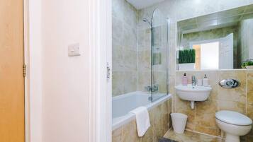 Un baño con bañera, lavabo e inodoro.