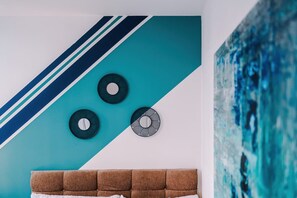 Ein Zimmer mit einer türkisfarbenen und weißen Wand, einem braunen Kopfteil und drei runden Wanddekorationen.