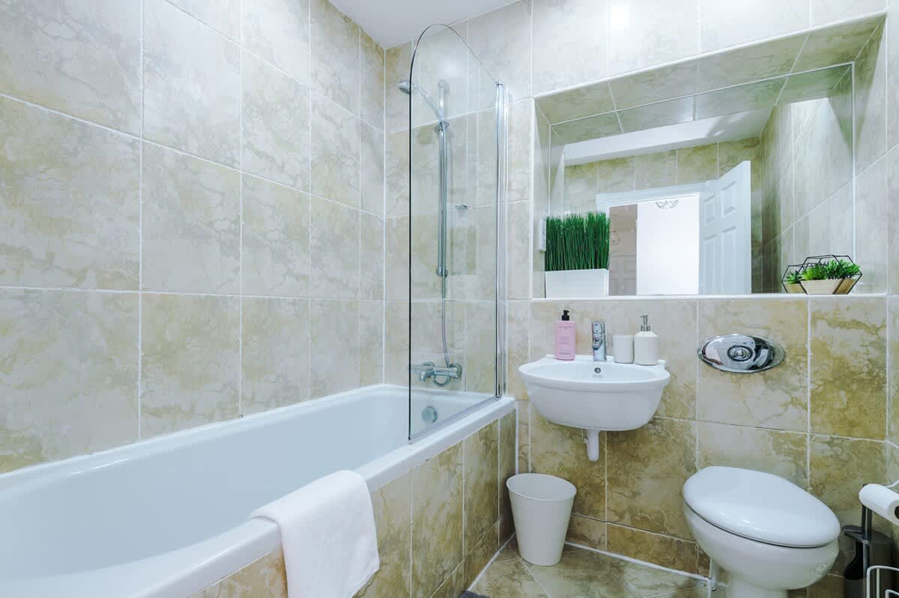 Un baño con bañera, lavabo e inodoro.