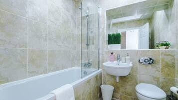 Un baño con bañera, lavabo e inodoro.