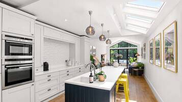 A modern kitchen with white cabinetry, a central island, and a skylight.