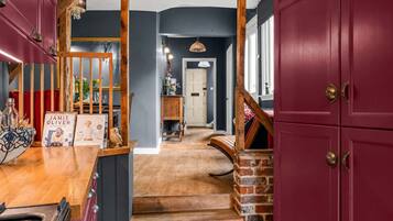 A staircase leading to a landing with a wooden railing and a red door.