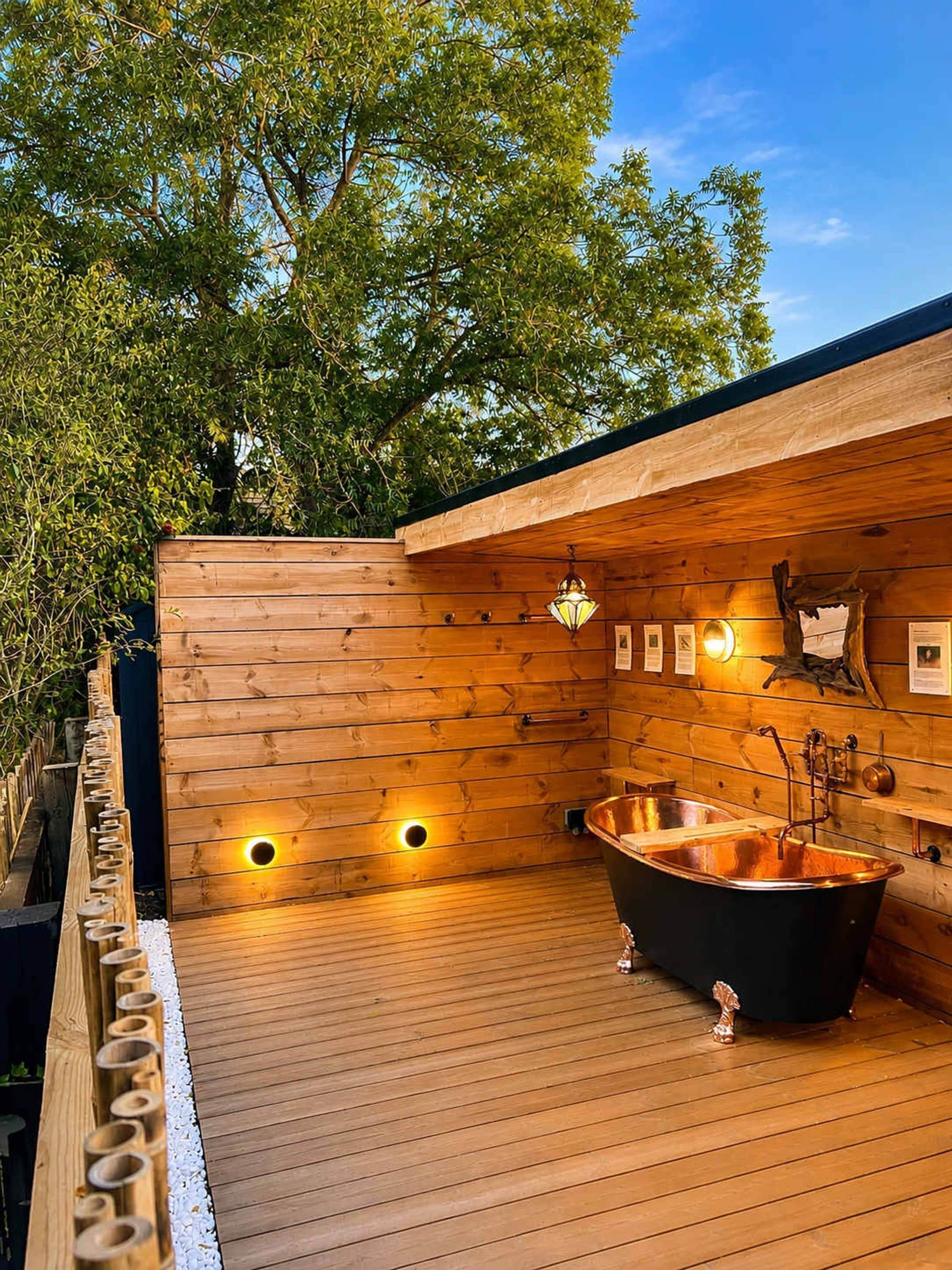 Une terrasse en bois avec un jacuzzi, des murs en bois et une clôture en bois.