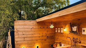 Une terrasse en bois avec un jacuzzi, des murs en bois et une clôture en bois.