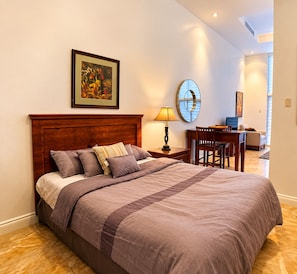 Een hotelkamer met een groot bed, een bureau en een stoel.