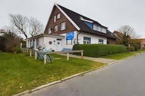 A two-story building with a sign for 'Strandhagens' and a visible entrance. - Holiday apartment cockle (Langeoog)