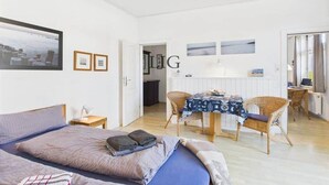 Un dormitorio con una cama, mesitas de noche y una ventana.