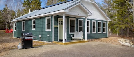 Un petit bâtiment d’un seul étage, doté d’un porche et d’un barbecue à l’extérieur.