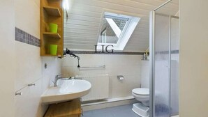 A bathroom with a skylight, a shower, and a toilet. - Holiday apartment Laughing Gull (Langeoog)