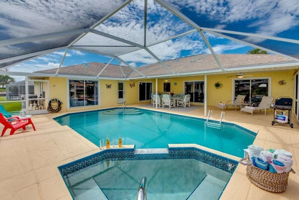 A covered outdoor swimming pool with a clear blue sky above.