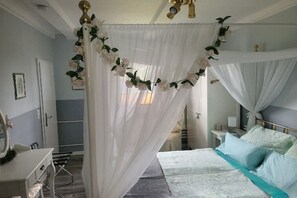A bedroom with a four-poster bed, a bedside table, and a mirror. - Holiday apartment with 3 bedrooms (Langelsheim)