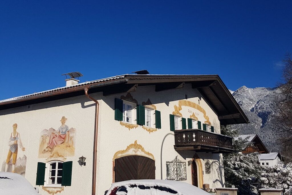 Un bâtiment doté d’un balcon, d’une porte et d’une fenêtre avec des volets.