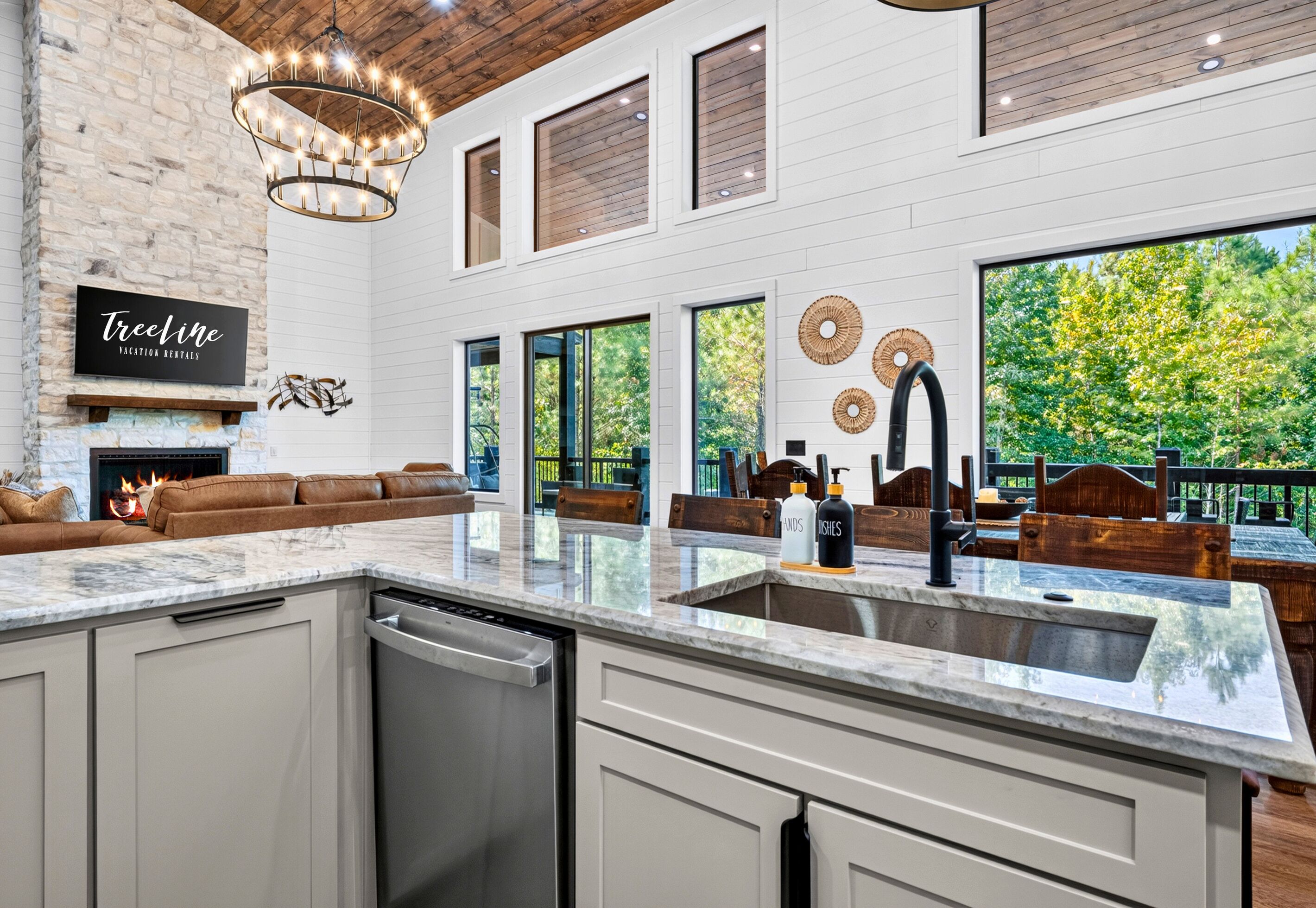 A spacious kitchen with a large island, a fireplace, and a view of the outdoors.
