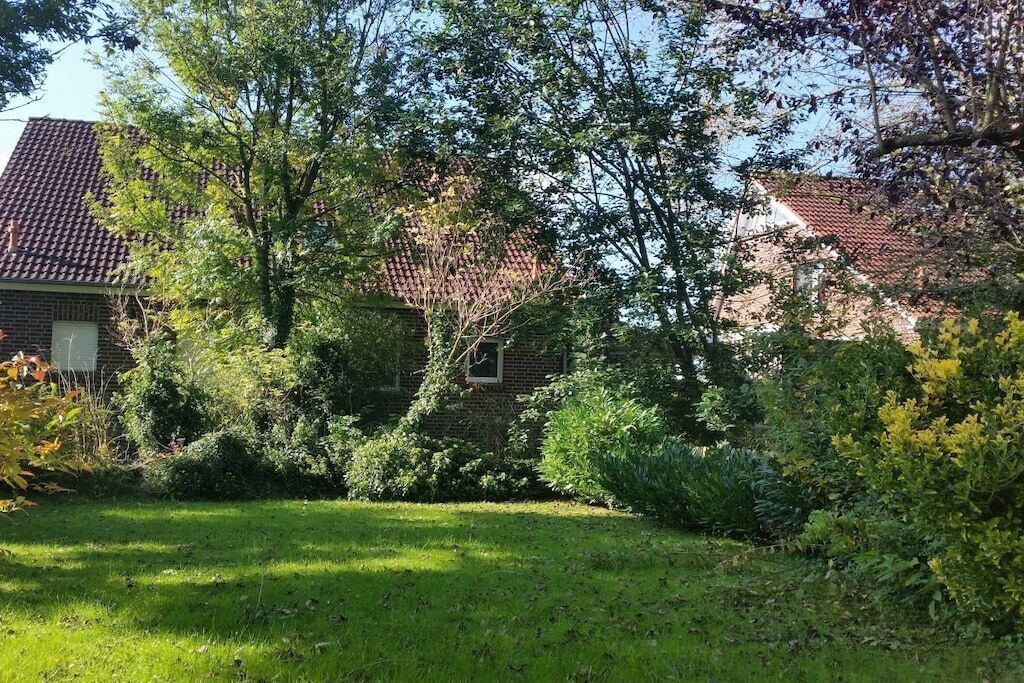 Ein Wohngebiet mit einem Ziegelhaus, einem gepflegten Rasen und reifen Bäumen.