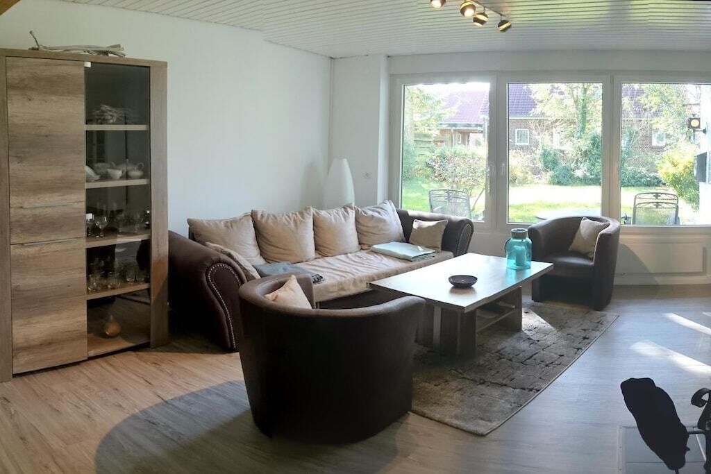 A modern living room with a sofa, coffee table, and a cabinet with glass doors.